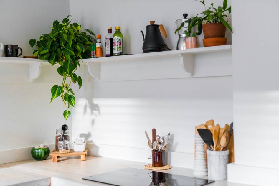 Stainless steel coffee mug on wooden table with green plants