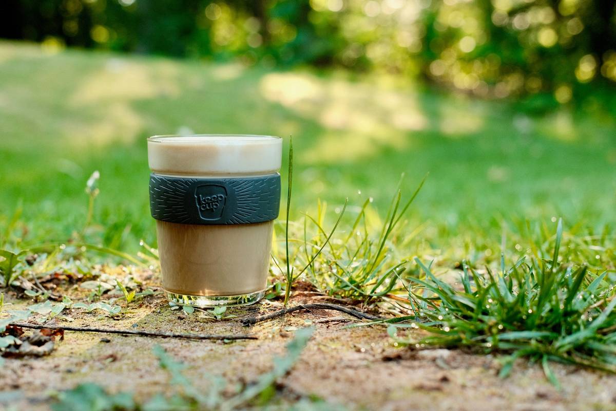 Close-up of a brushed stainless steel earth friendly coffee mug on a reclaimed wood countertop